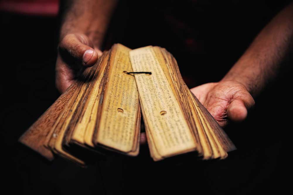 Prayer book of papyrus in the hands of Buddhist monk